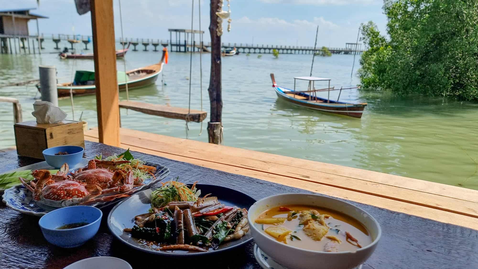 A well-set table adorned with various dishes, surrounded by the serene waters of a lake or ocean