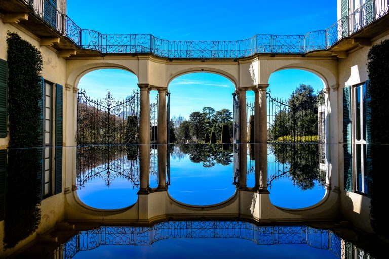 Beautiful shot of water in a pool reflecting the gates of the house at daytime