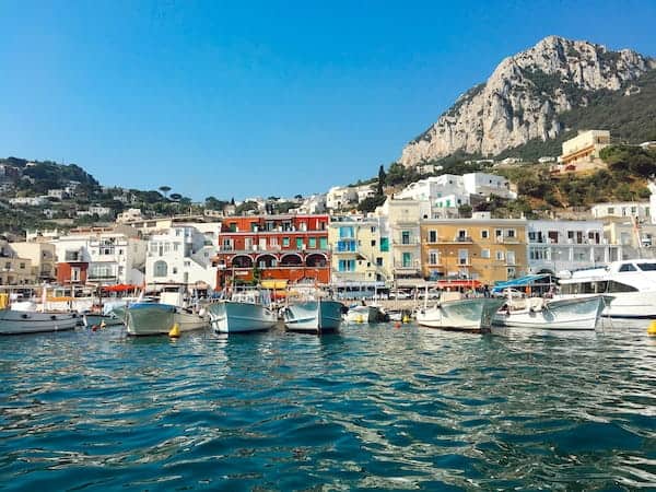 7-Day Amalfi Coast Itinerary: Planned Around How It Feels To Be There 4 Scenic Harbour In Capri, Italy, With Colourful Buildings And Boats On Turquoise Water, Framed By A Mountainous Backdrop Under A Clear Blue Sky.