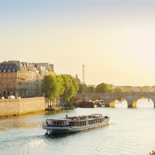 Pont Neuf and Seine river with tour boat at sunny summer sunset, Paris, France
